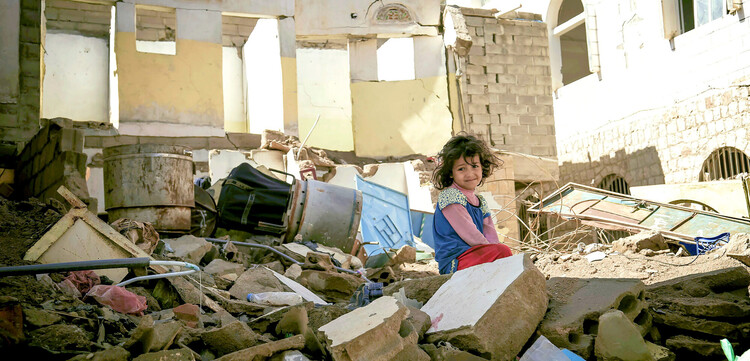 Ein Mädchen im Jemen sitzt auf Trümmern