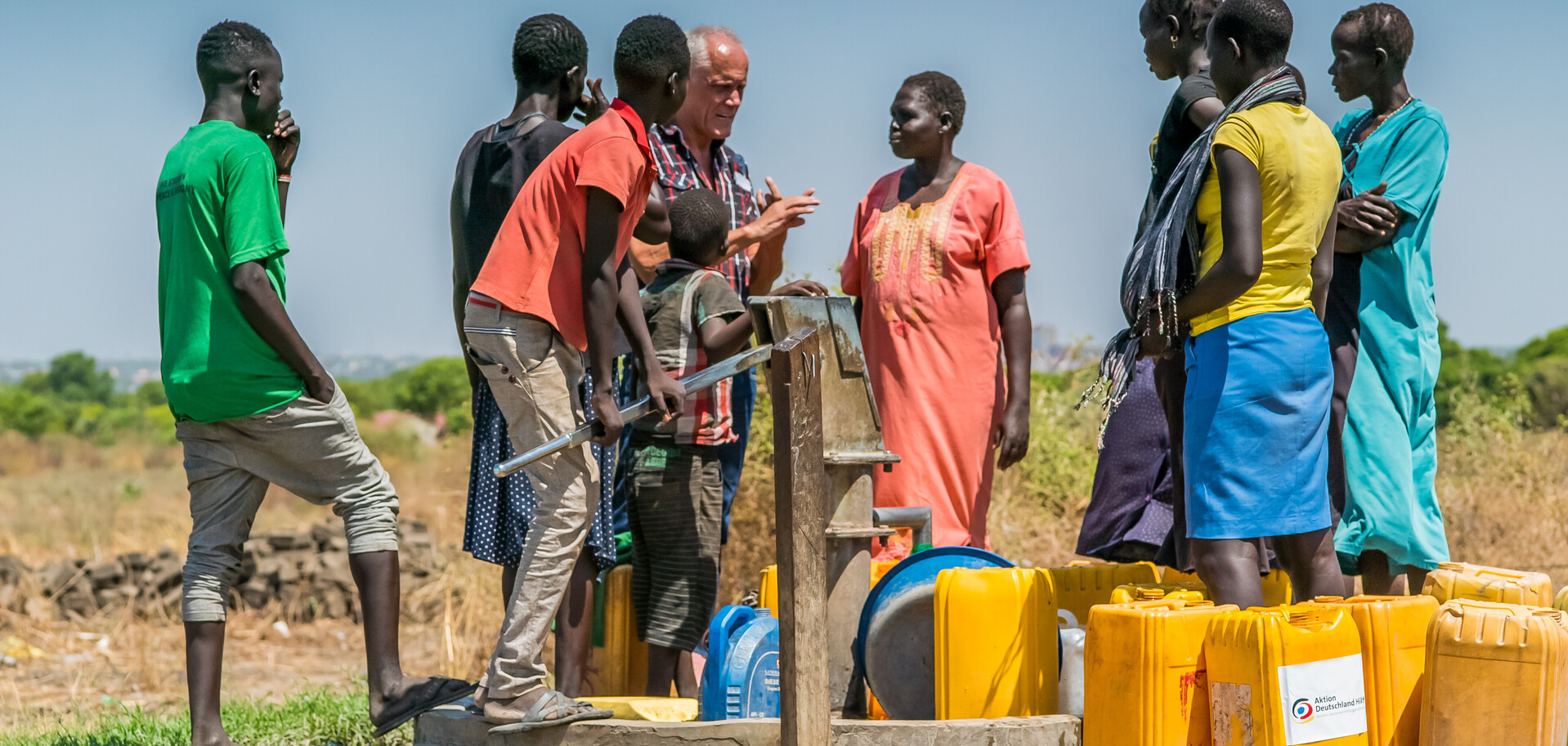Zugang zu Wasser: Männer und Frauen im Südsudan an einem Brunnen Zugang zu Wasser: Männer und Frauen im Südsudan an einem Brunnen