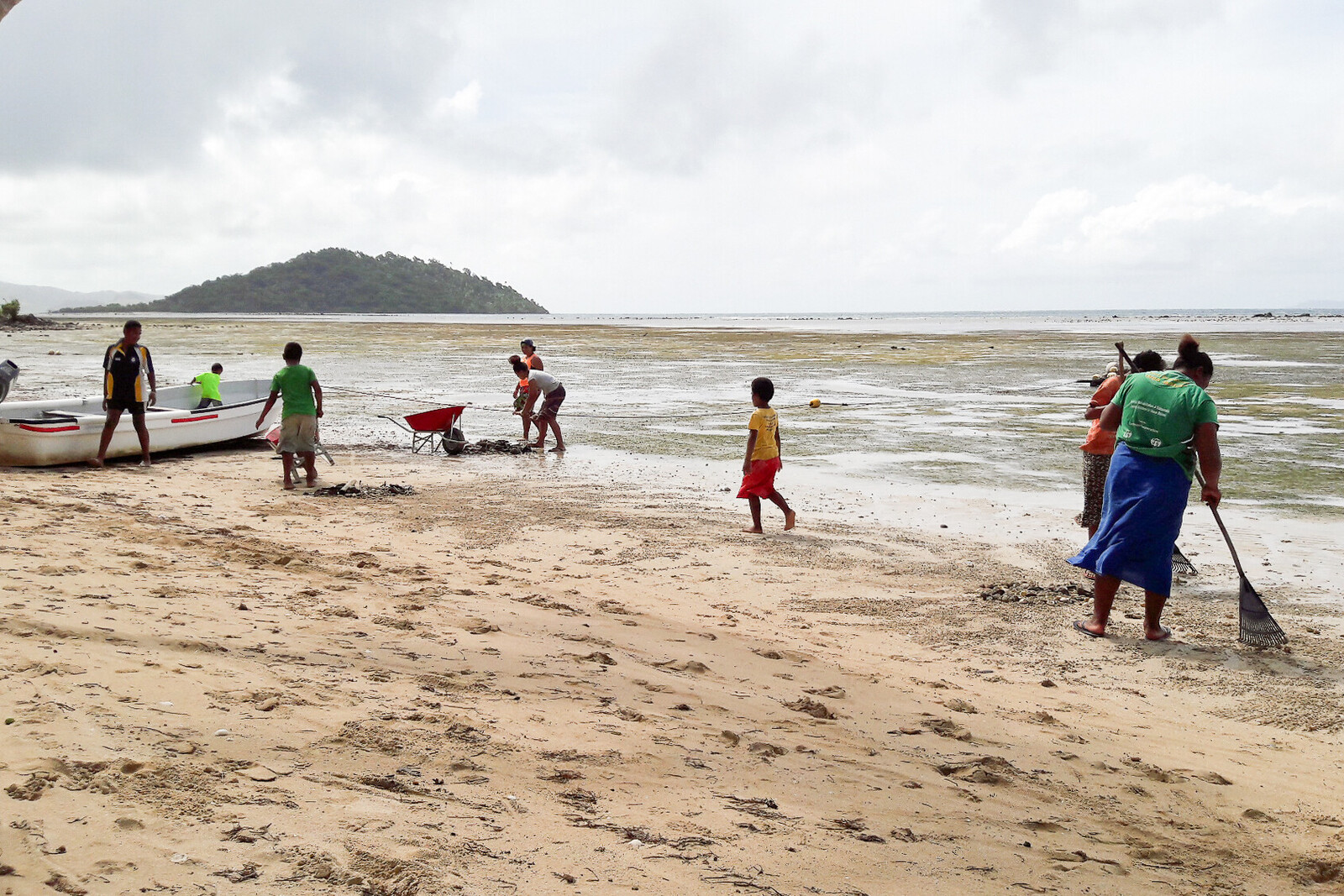 Menschen aus Fidschi, einem Land Ozeaniens, bei der Reinigung des Strandes
