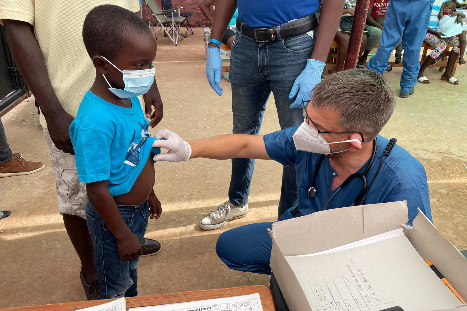 Ein Helfer des BRH untersucht ein Kind in Haiti 