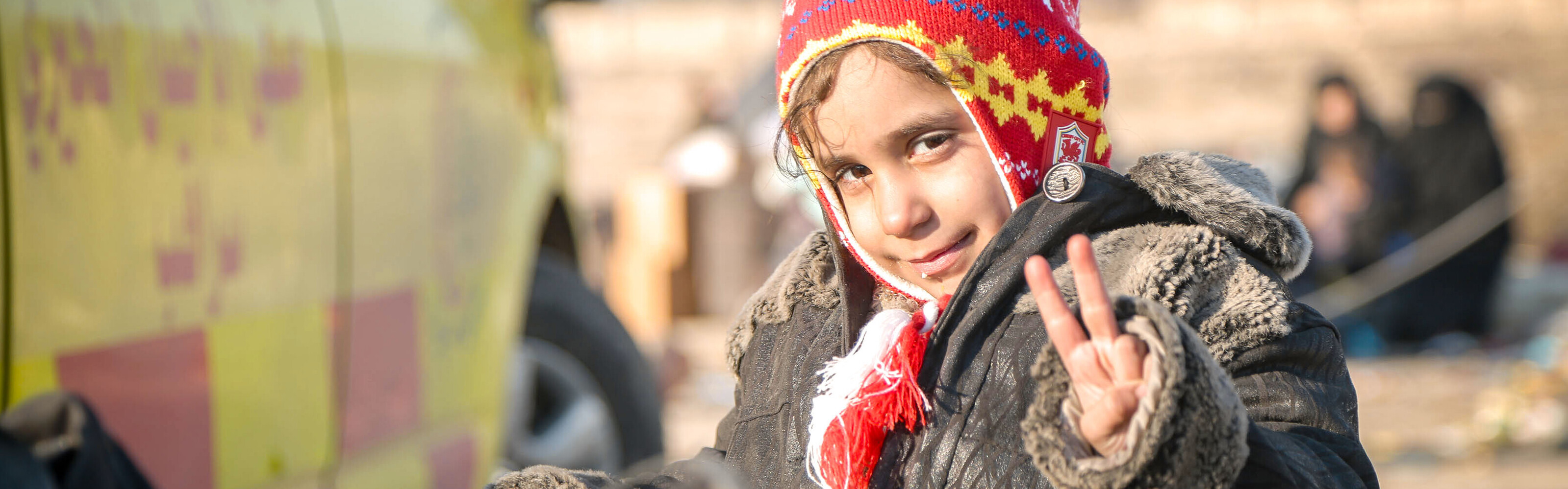 Ein Mädchen aus Syrien freut sich nach der Evakuierung aus Aleppo.