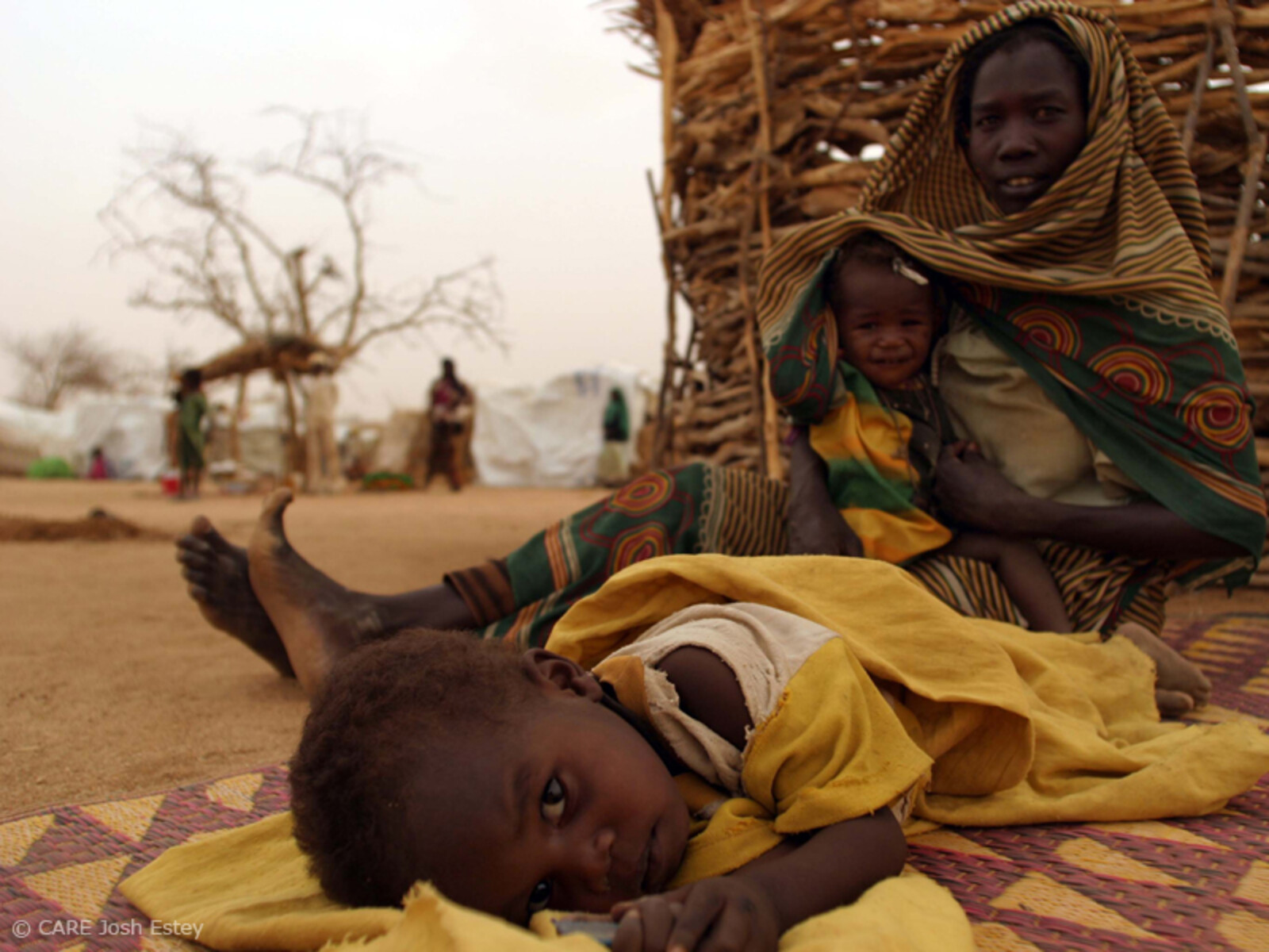 Kleiner Junge mit seiner Mutter in einem Flüchtlingslager im Tschad