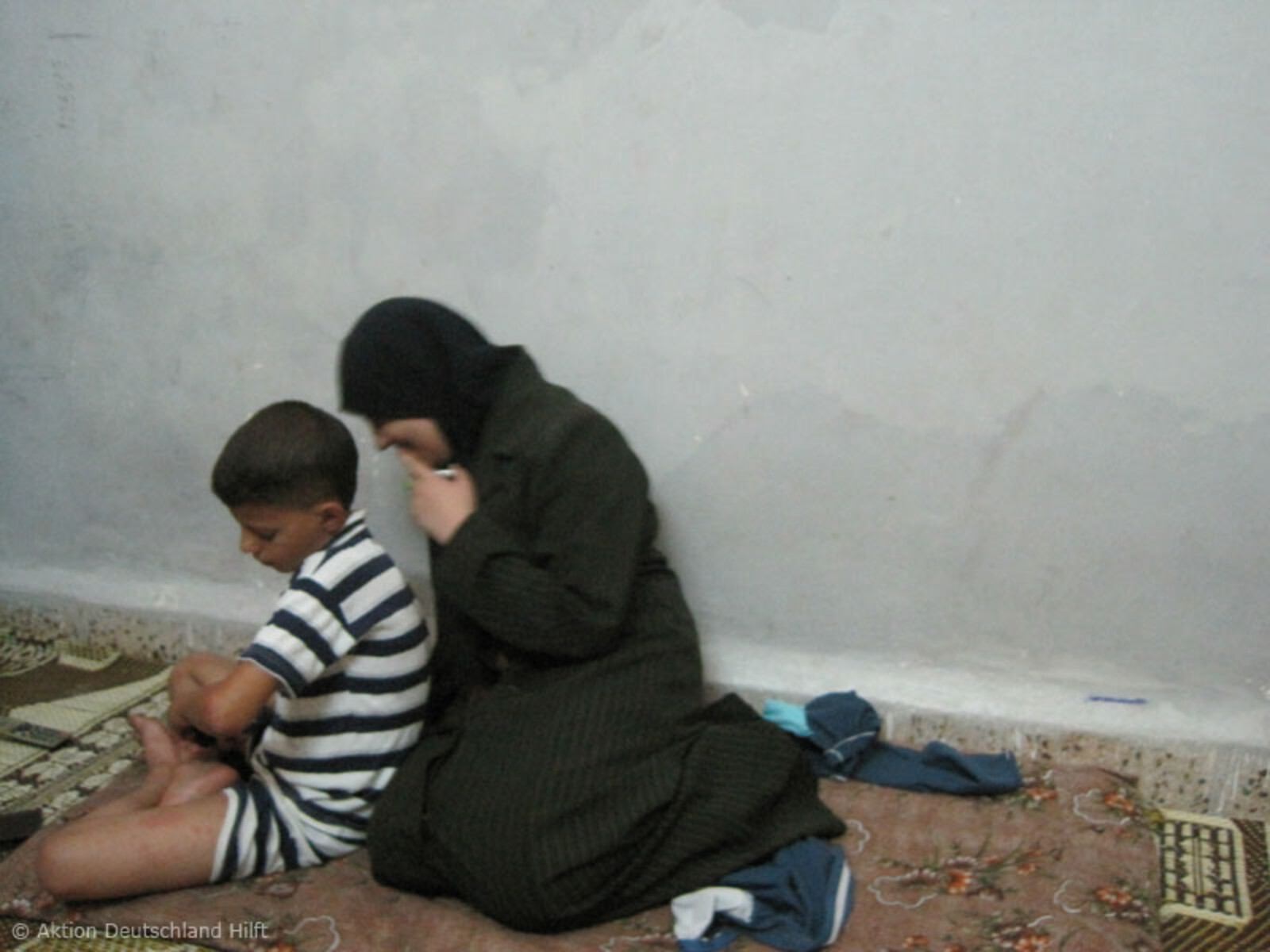 Mutter und Sohn in Notunterkunft in Jordanien