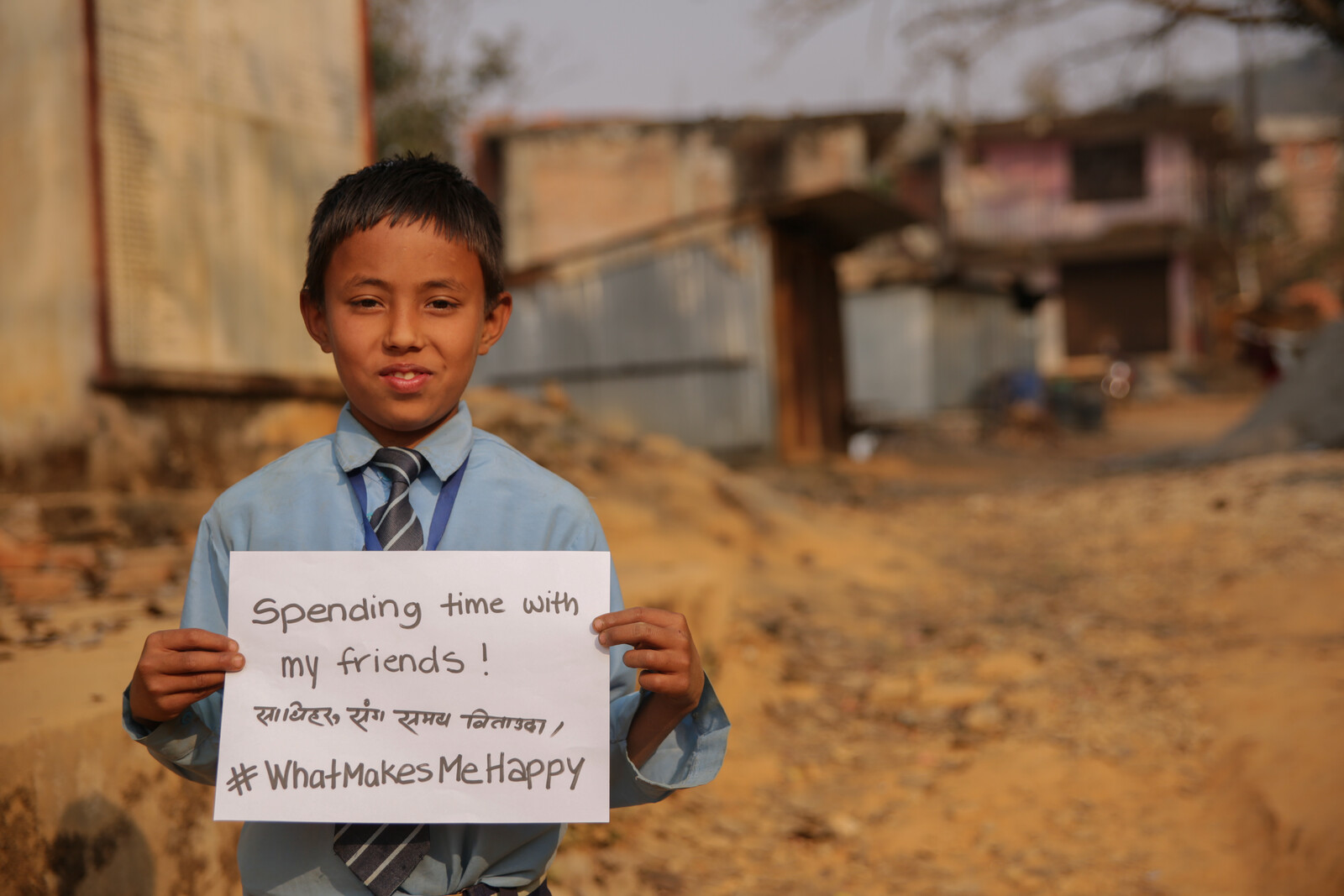 Ein Junge in Nepal ist glücklich über seine Familie.