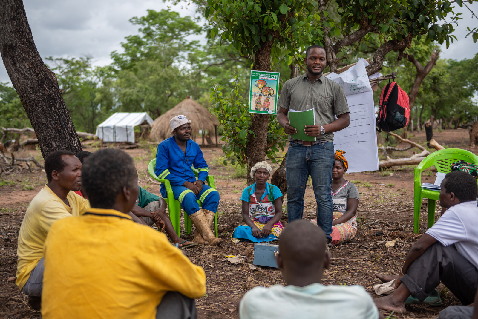 Katastrophenvorsorge in Mosambik: Ein Helfer erklärt einer Dorfgemeinde, wie wichtig Geldanlagen in Krisenzeiten sind