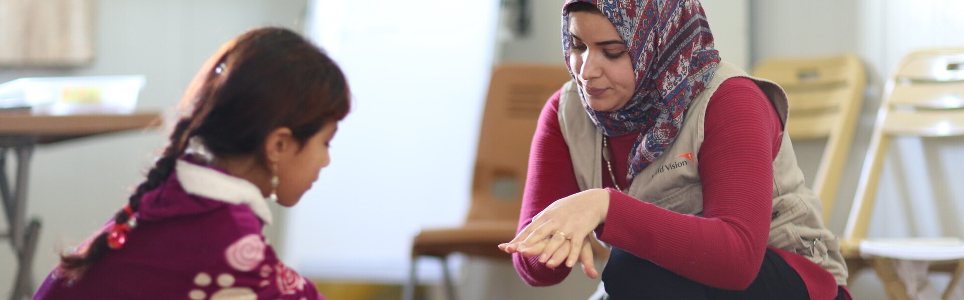 Eine Helferin zeigt einem Mädchen das richtige Händewaschen Eine Helferin zeigt einem Mädchen das richtige Händewaschen