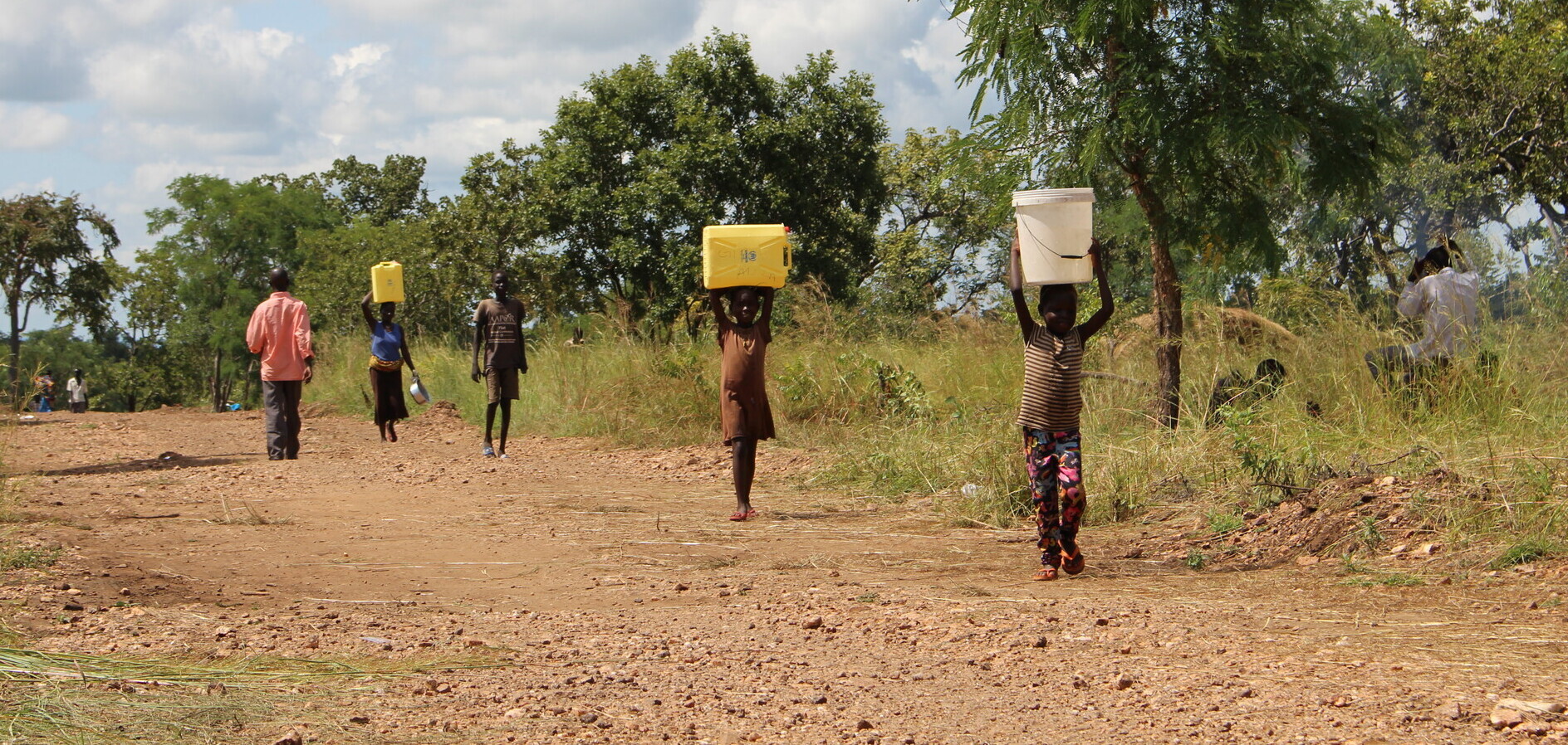 Kinder und Frauen beim Wasserholen in Uganda Kinder und Frauen beim Wasserholen in Uganda