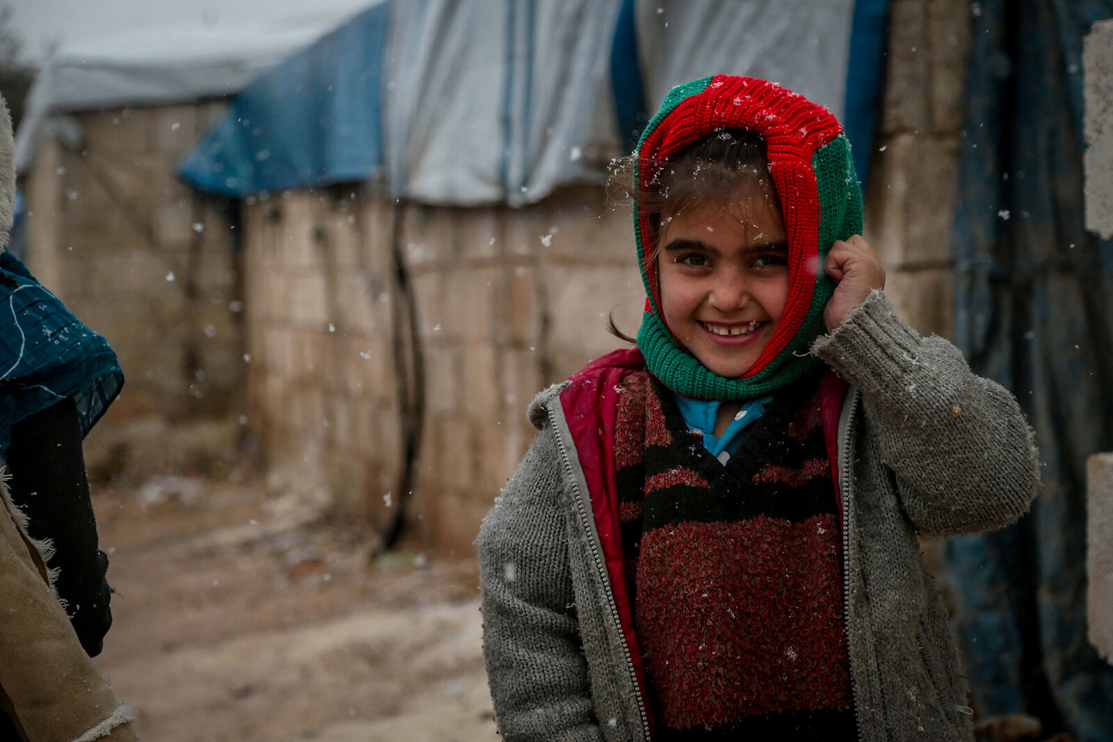 Ein Mädchen hat warme Winterkleidung in Aleppo an
