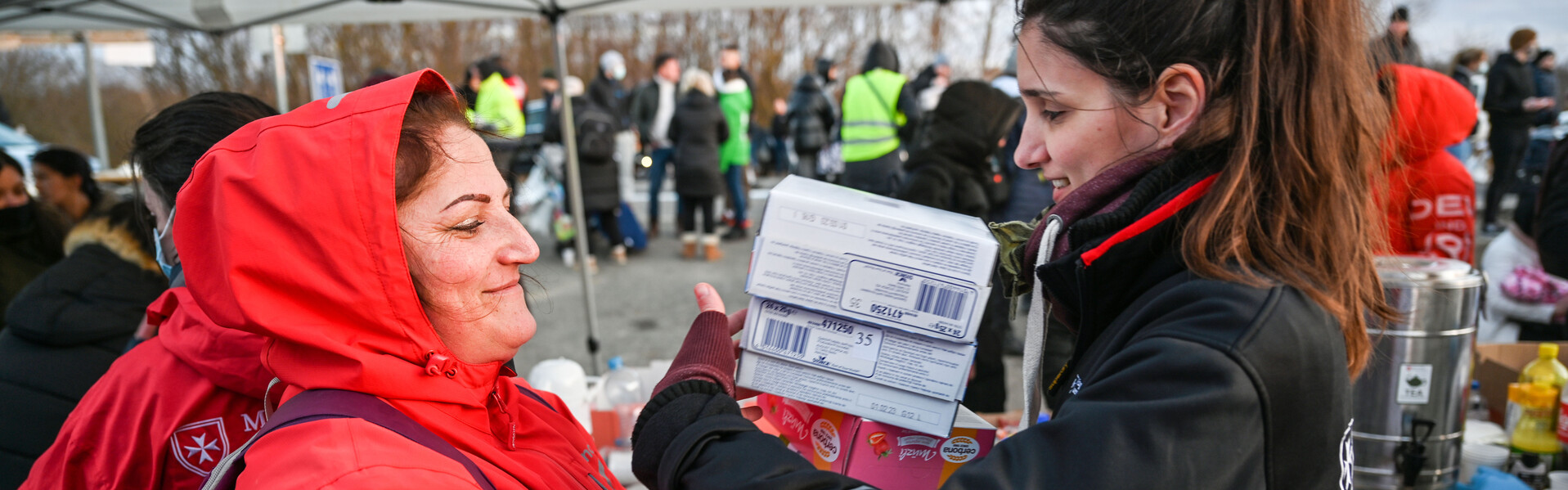 Eine Helferin der Malteser übergibt Hilfsgüter an eine Frau aus der Ukraine Eine Helferin der Malteser übergibt Hilfsgüter an eine Frau aus der Ukraine