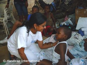 Haiti: Helferin von Handicap International kümmert sich um ein Kind