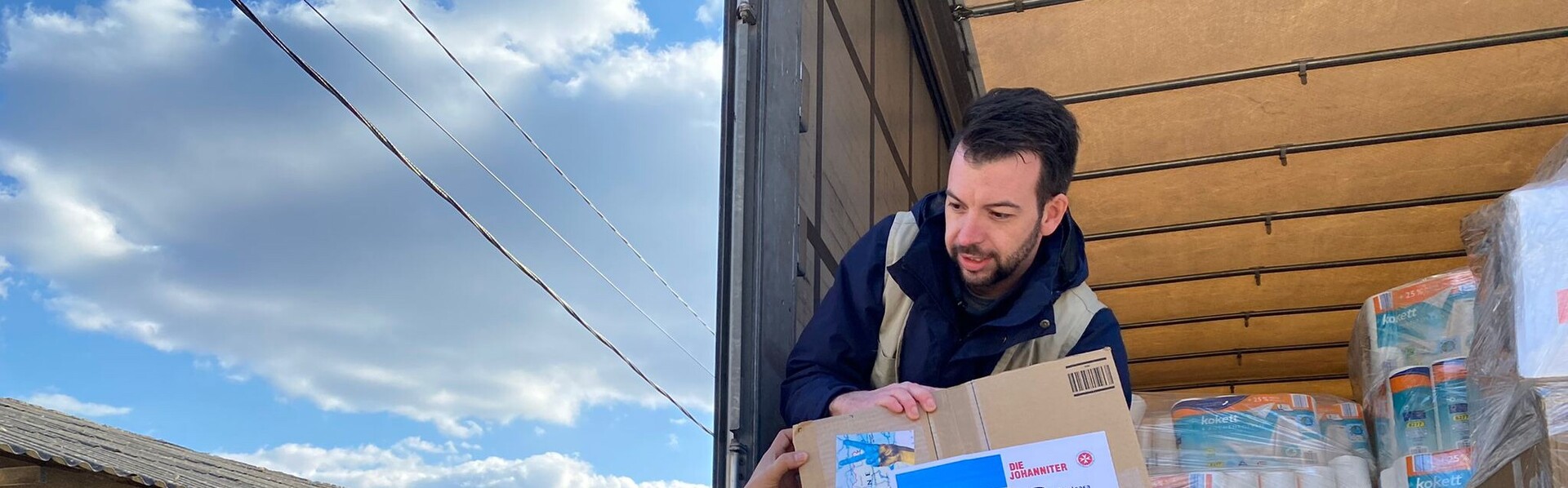Helfer laden einen LKW mit Hilfsgütern aus Helfer laden einen LKW mit Hilfsgütern aus
