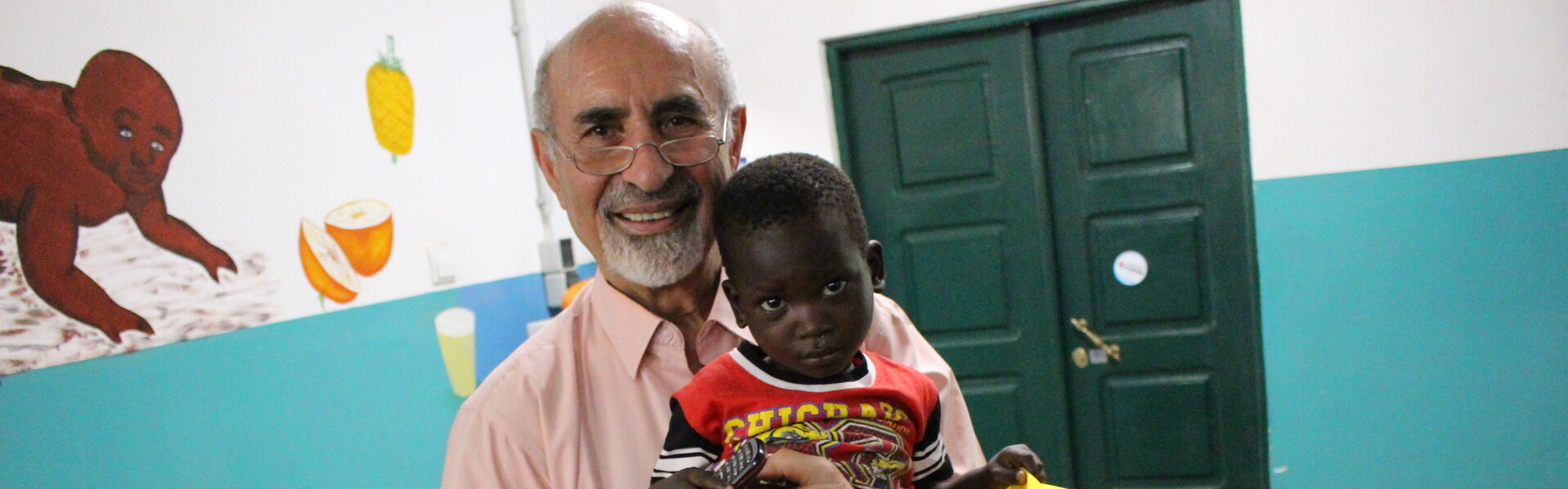 Dr. Emmanouilidis mit einem Kind in der Kinderambulanz in Guinea-Bissau Dr. Emmanouilidis mit einem Kind in der Kinderambulanz in Guinea-Bissau