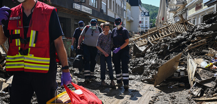 Einsatzkräfte der Johanniter helfen einer Frau im Hochwassergebiet