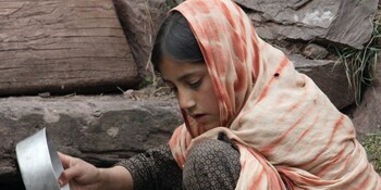 Ein Mädchen füllt Trinkwasser in einen Krug Ein Mädchen füllt Trinkwasser in einen Krug