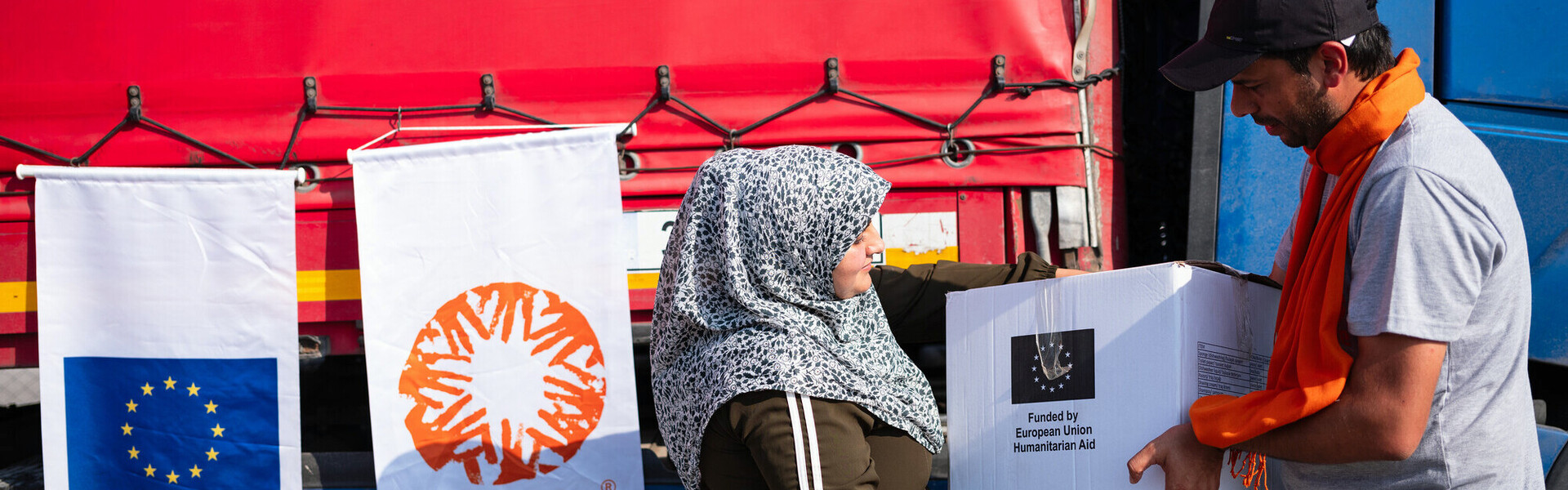 Ein Helfer von CARE überreicht einer Frau ein Hilfspaket Ein Helfer von CARE überreicht einer Frau ein Hilfspaket