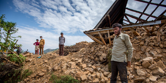 Menschen stehen in Schutt und Asche nach einem Erdbeben. Menschen stehen in Schutt und Asche nach einem Erdbeben.