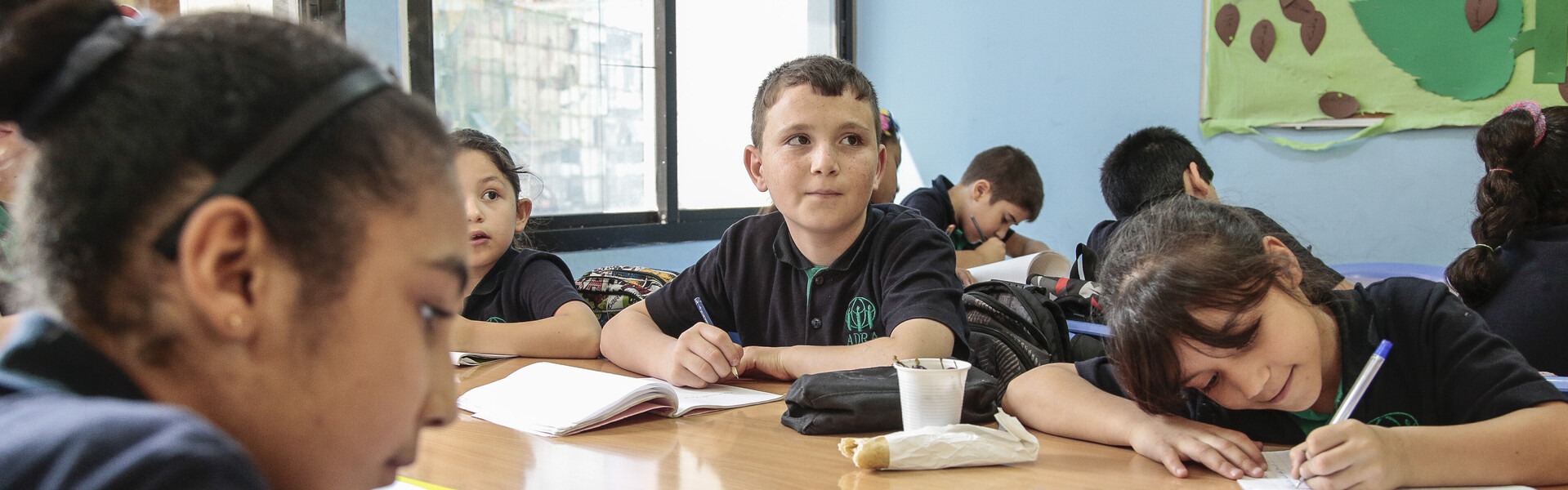 Adnan sitzt mit seinen Mitschülern in der Klasse und löst Aufgaben. Adnan sitzt mit seinen Mitschülern in der Klasse und löst Aufgaben.