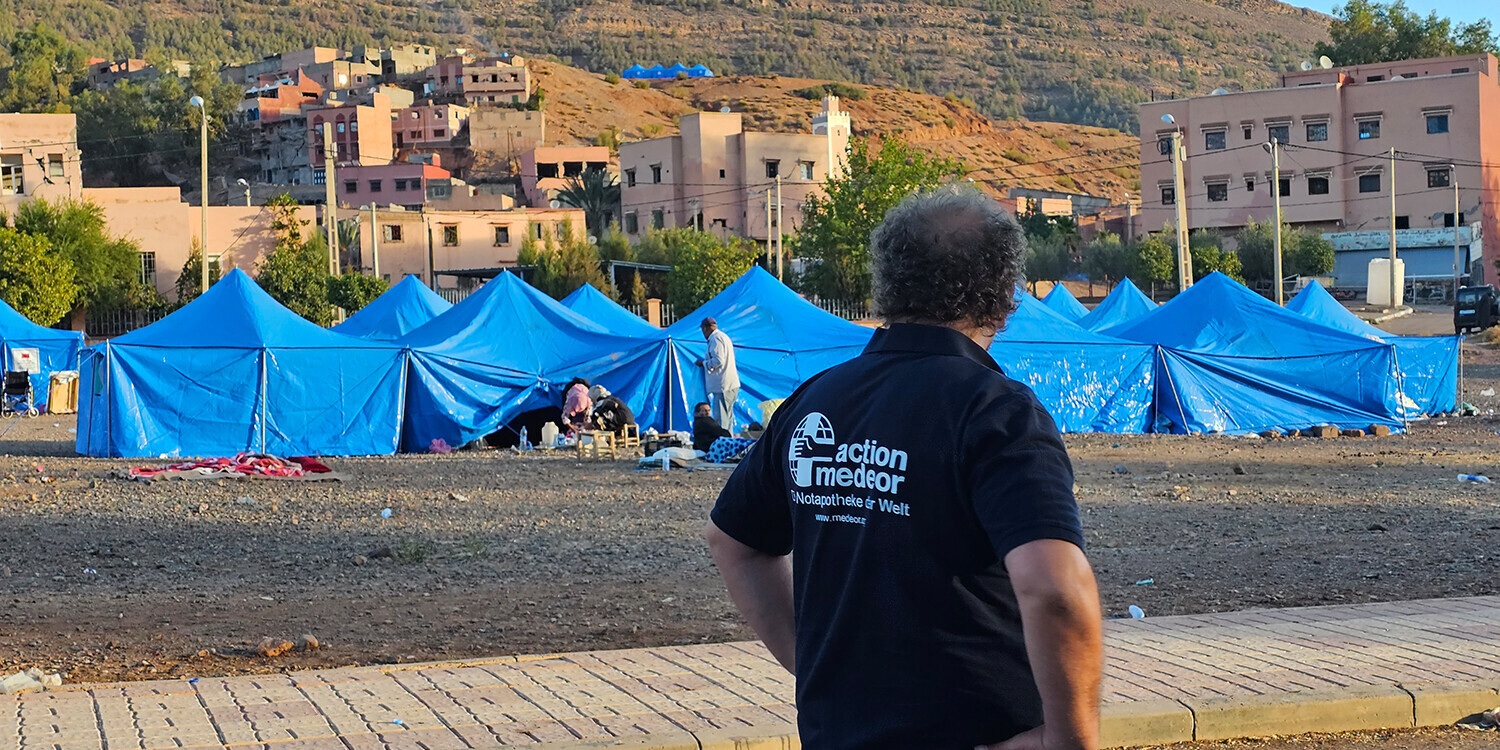 Nach dem Erdbeben in Marokko richteten Helfer:innen Zeltlager für Betroffene ein Ein Helfer von action medeor blickt auf das Zeltlager in einem Bergdorf in Marokko
