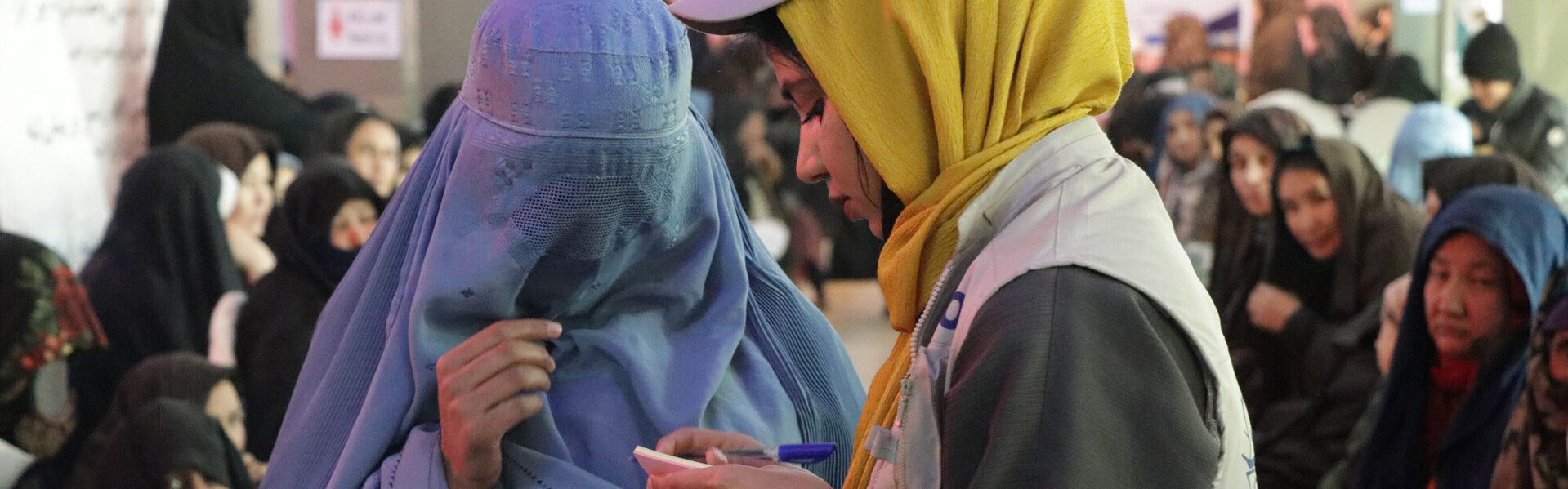 Eine Helferin spricht mit einer Frau, die eine Burka trägt, Copyright Help – Hilfe zur Selbsthilfe Eine Helferin spricht mit einer Frau, die eine blaue Burka trägt, Copyright Help – Hilfe zur Selbsthilfe