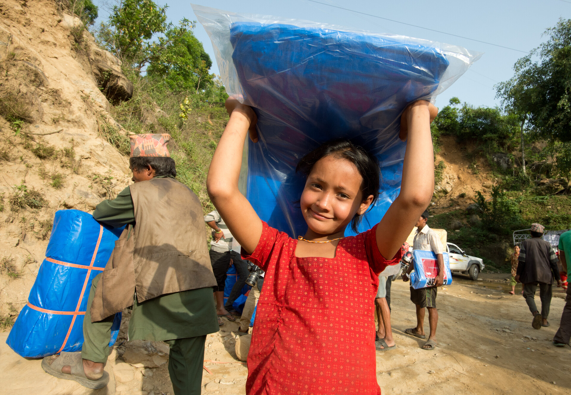 In Nepal hält ein Mädchen eine Matratze hoch nach dem Erdbeben. In Nepal hält ein Mädchen eine Matratze hoch nach dem Erdbeben.