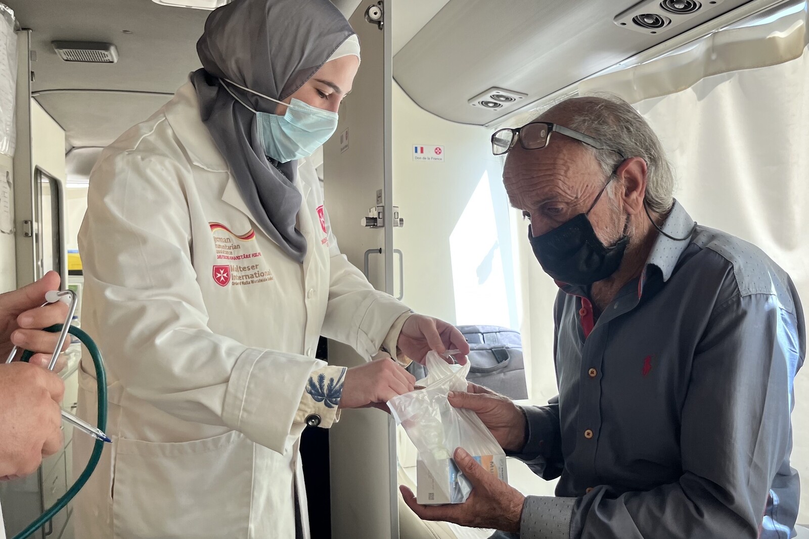 Eine Frau leistet im Libanon einem Mann medizinische Hilfe