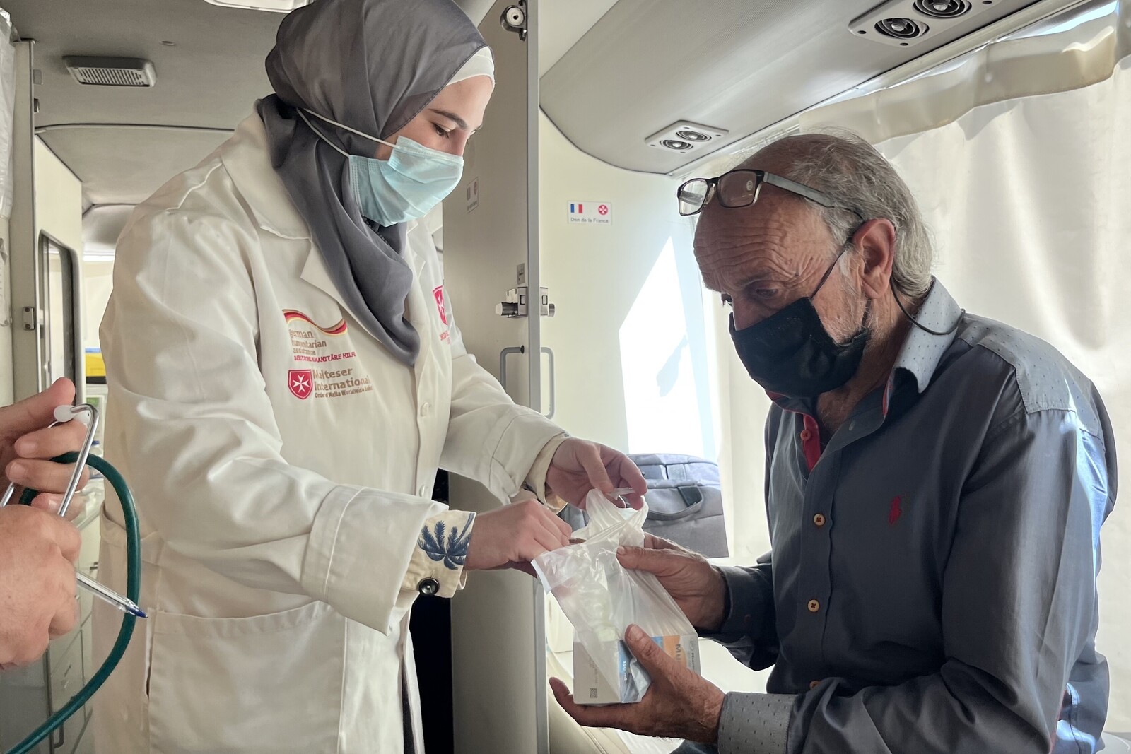 Eine Frau leistet im Libanon einem Mann medizinische Hilfe