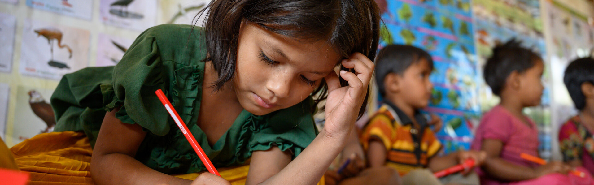 Ein Mädchen in Bangladesch löst Aufgaben in einem Schulbuch Ein Mädchen in Bangladesch löst Aufgaben in einem Schulbuch
