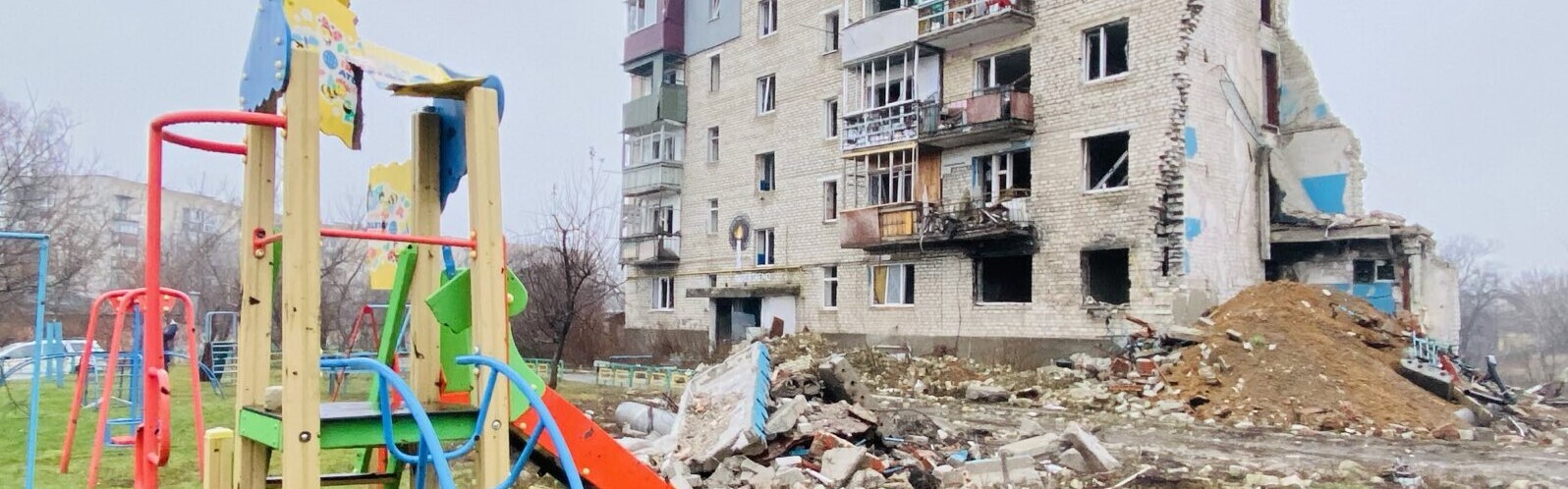 Ein von Bomben zerstörter Spielplatz vor einem Wohnhaus in der Ukraine Ein von Bomben zerstörter Spielplatz vor einem Wohnhaus in der Ukraine