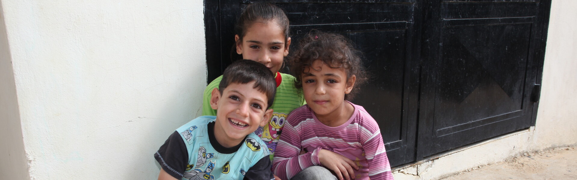 Flüchtlingskinder sitzen auf einer Straße. Flüchtlingskinder sitzen auf einer Straße.