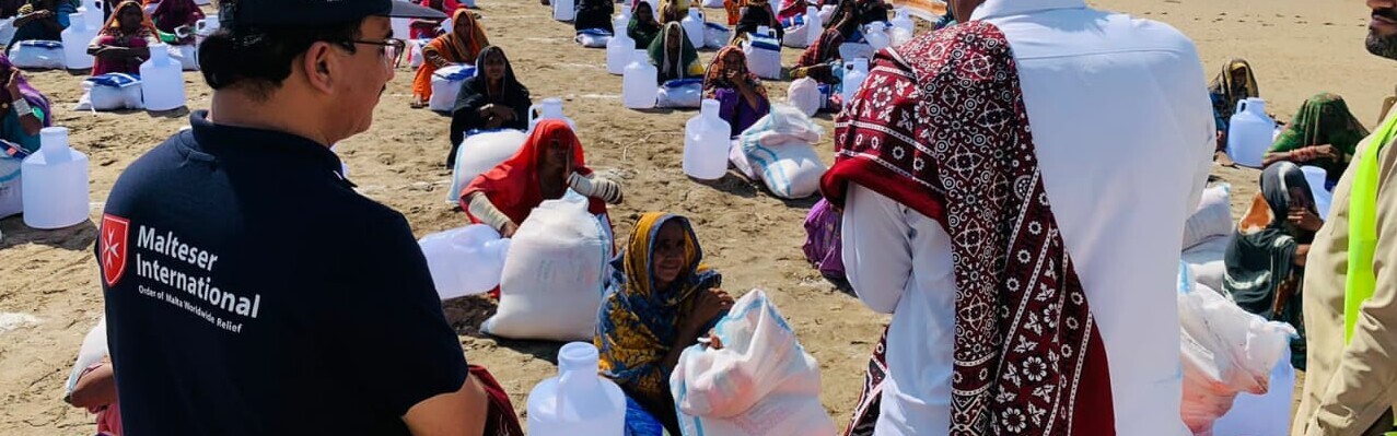 Helfer der Organisation Malteser International versorgen die von der Flut betroffenen Menschen mit Wasser und Lebensmittel Helfer der Organisation Malteser International versorgen die von der Flut betroffenen Menschen mit Wasser und Lebensmittel