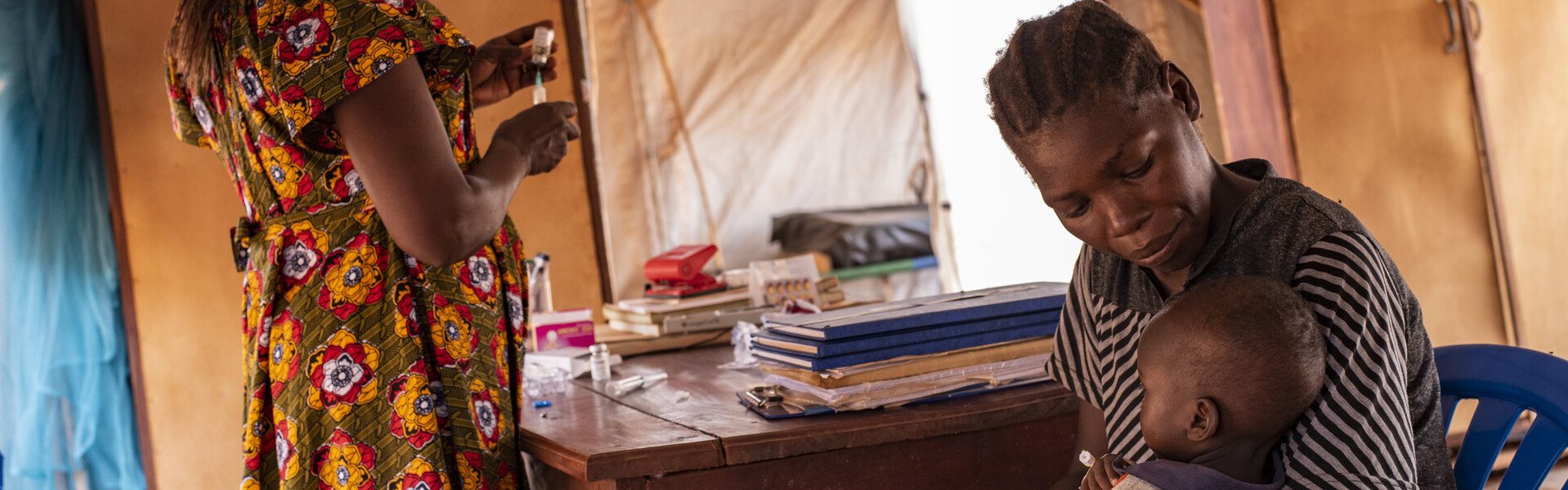 Eine Helferin versorgt eine Mutter und ihr Kind im Südsudan medizinisch Eine Helferin versorgt eine Mutter und ihr Kind im Südsudan medizinisch