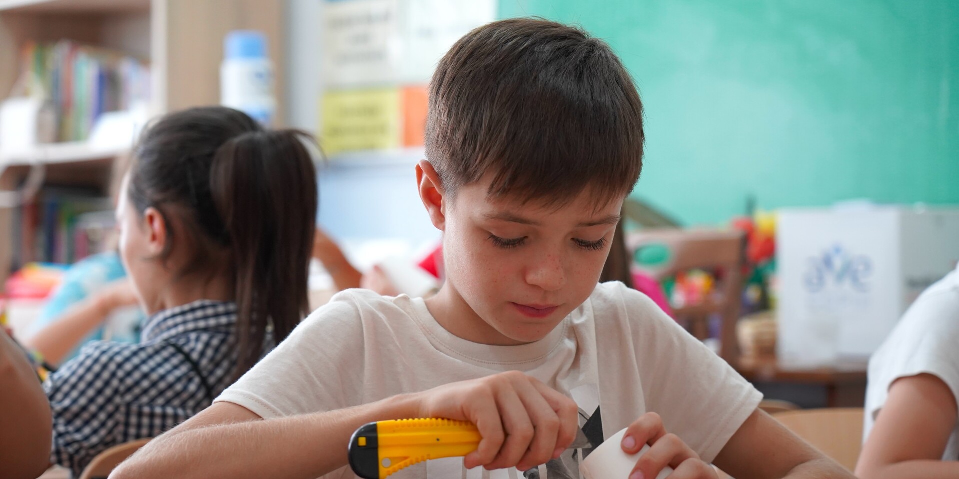Kind bastelt mit einem Plastikbecher im Rahmen eines Hilfsprojekt Kind bastelt mit einem Plastikbecher im Rahmen eines Hilfsprojekt