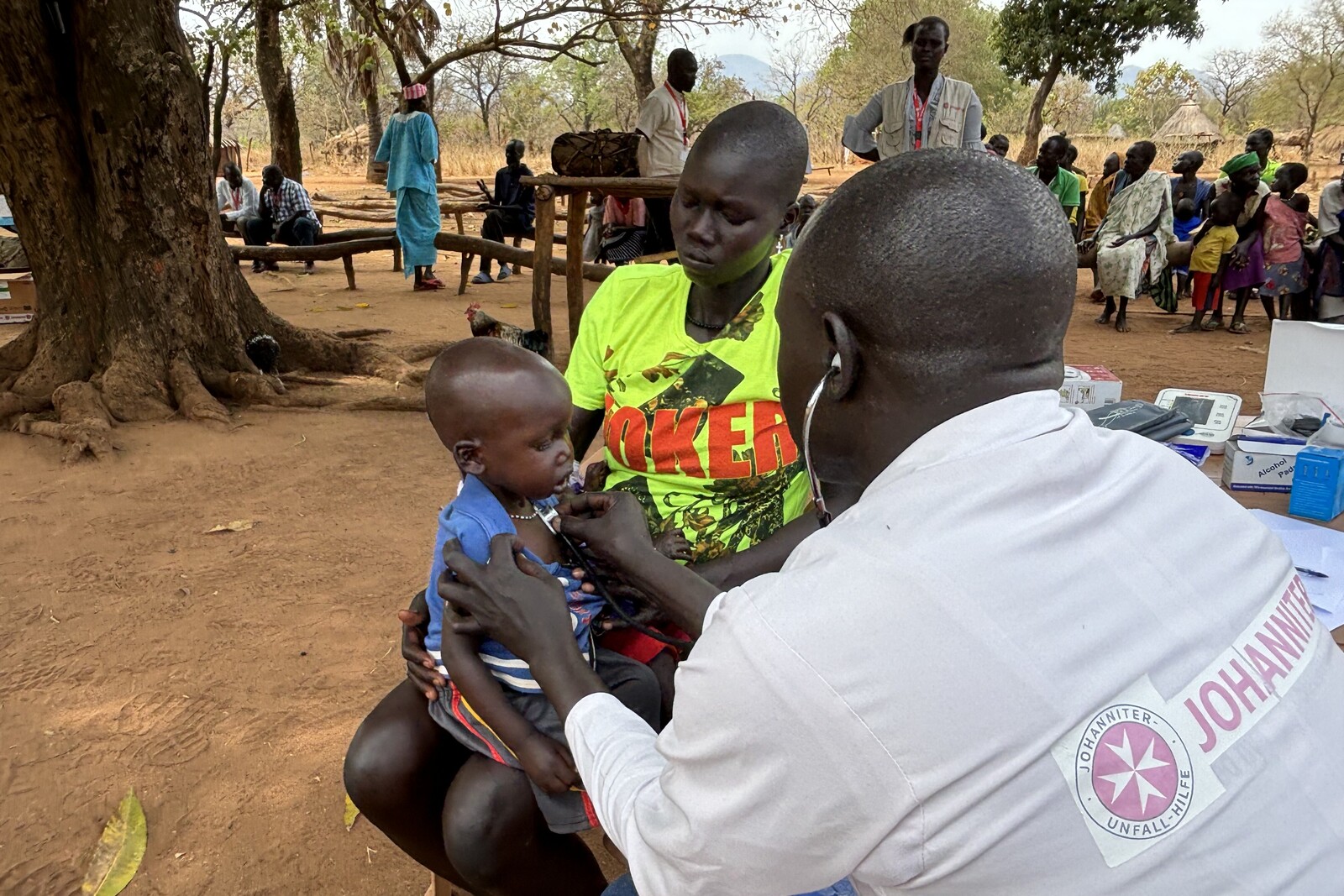 Helfer im Südsudan untersucht Kind