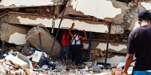 Eine Frau und ein Mann stehen vor einem zerstörten Gebäude in Venezuela Eine Frau und ein Mann stehen vor einem zerstörten Gebäude in Venezuela