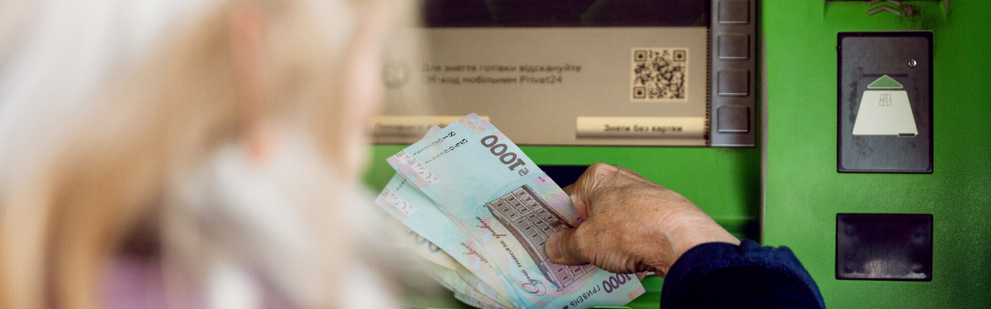 Frau in der Ukraine an einem Geldautomatten Frau in der Ukraine an einem Geldautomatten