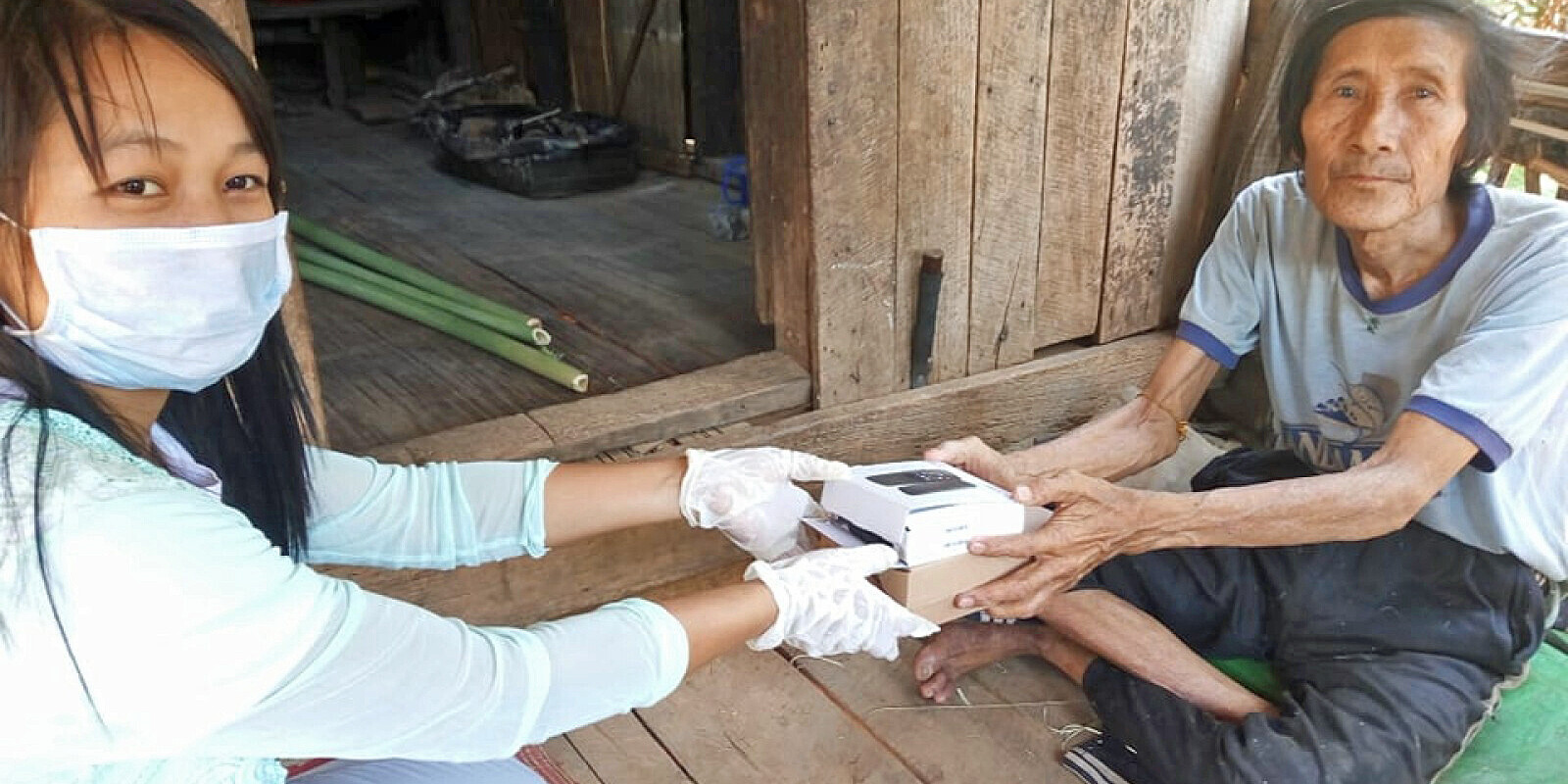 Eine Helferin verteilt Handys an Menschen in Myanmar Eine Helferin verteilt Handys an Menschen in Myanmar