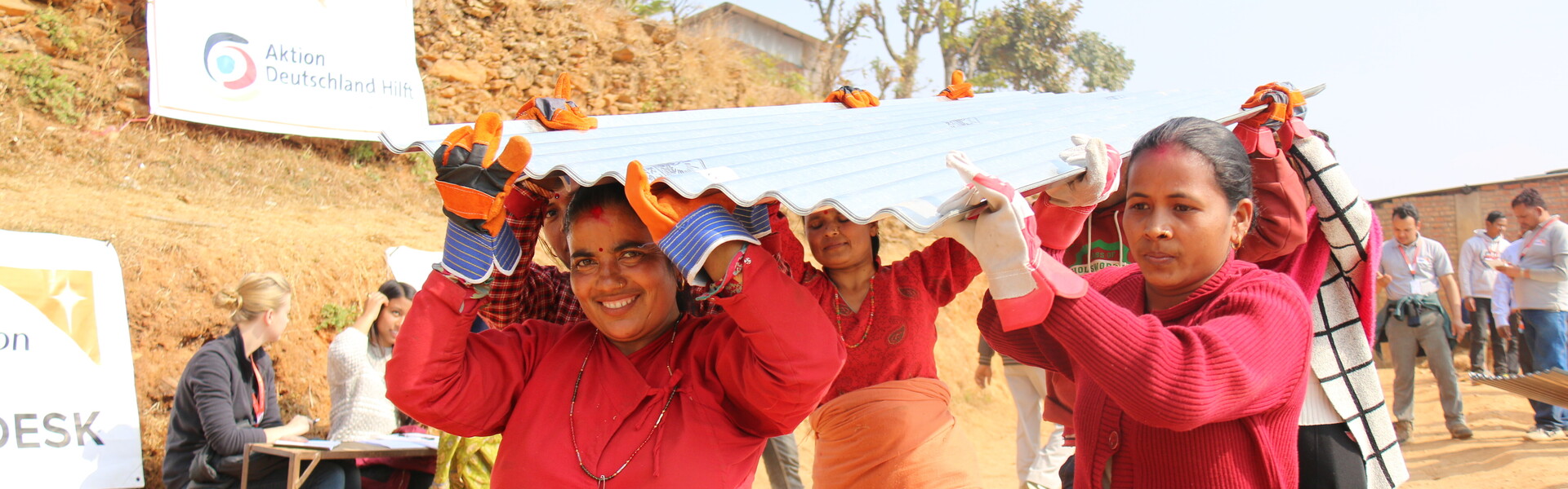 Ein Jahr nach dem Erdbeben sieht man die Erfolge des Wiederaufbaus. Eine Frau und ihre Familie erhalten Wellblech für eine neue Hütte. Ein Jahr nach dem Erdbeben sieht man die Erfolge des Wiederaufbaus. Eine Frau und ihre Familie erhalten Wellblech für eine neue Hütte.