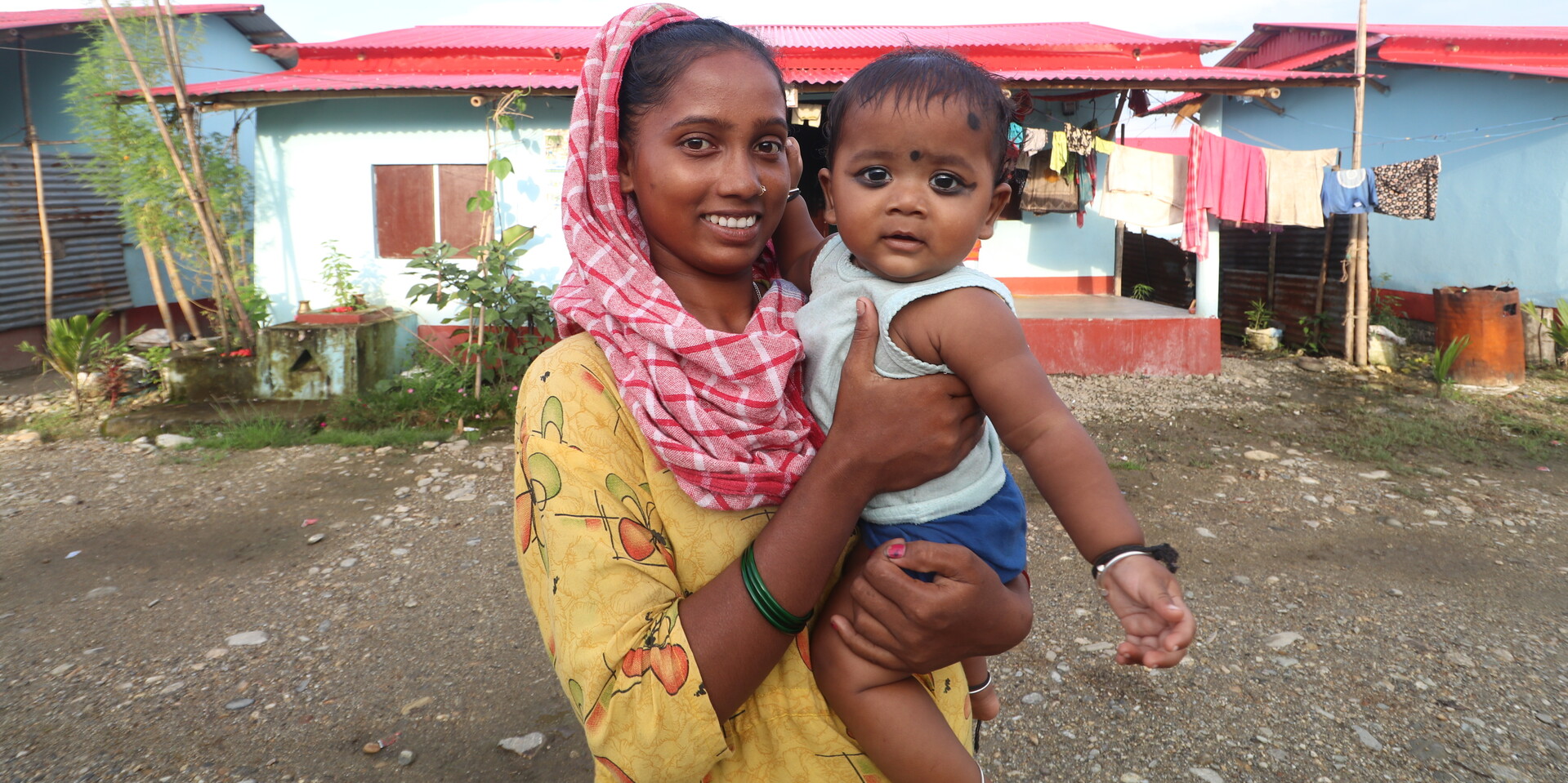 Runa steht mit ihrer Tochter vor dem eigenen Bambushaus Runa steht mit ihrer Tochter vor dem eigenen Bambushaus