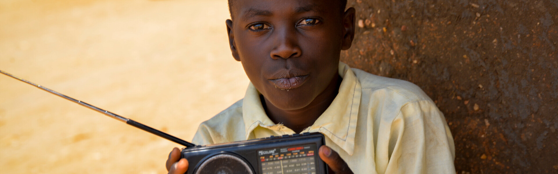 Über ein kleines tragbares Radio empfängt Samuel aus Uganda die neuesten Meldungen zum Coronavirus Über ein kleines tragbares Radio empfängt Samuel aus Uganda die neuesten Meldungen zum Coronavirus