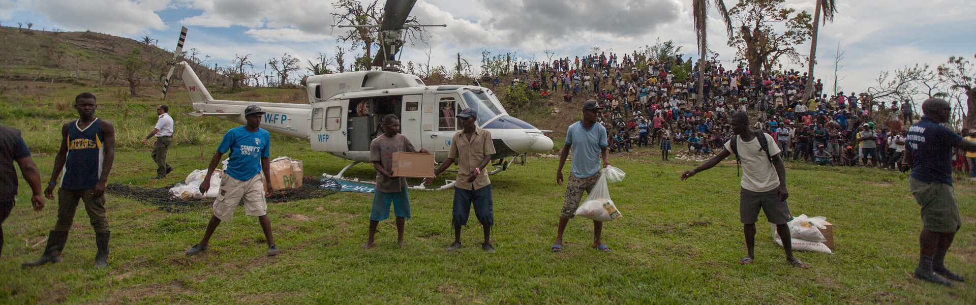 Helfer von der Hilfsorganisation ADRA verteilen Nothilfepakete aus einem Helikopter an die Betroffenen des Hurrikan Matthew in Haiti Helfer von der Hilfsorganisation ADRA verteilen Nothilfepakete aus einem Helikopter an die Betroffenen des Hurrikan Matthew in Haiti