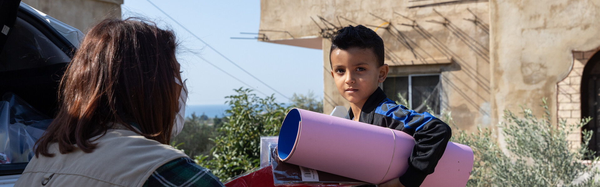 Eine Helferin von World Vision überreicht einem Kind im Libanon Spielsachen Eine Helferin von World Vision überreicht einem Kind im Libanon Spielsachen