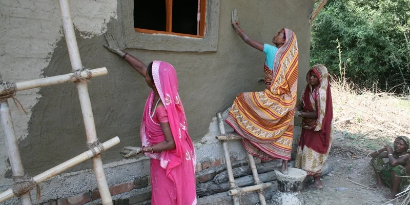 Frauen in Nepal verputzen ein Bambushaus Frauen in Nepal verputzen ein Bambushaus