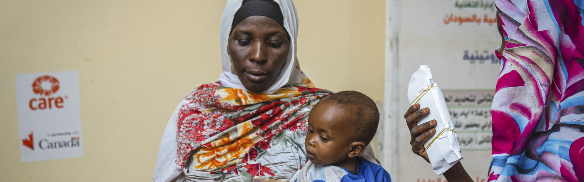 Eine Mutter im Sudan gemeinsam mit ihrem Kind, während sie finanzielle Nothilfe erhält Eine Mutter im Sudan gemeinsam mit ihrem Kind, während sie finanzielle Nothilfe erhält