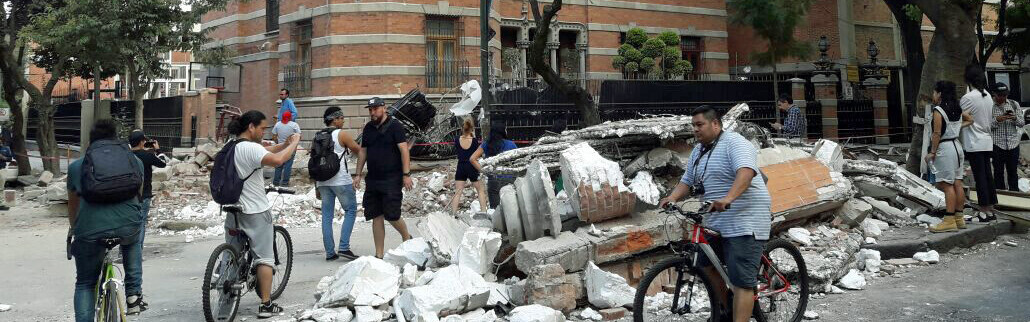 In Mexiko verwüstete ein Erdbeben viele Häuser. Menschen stehen vor einer Häuserruine. In Mexiko verwüstete ein Erdbeben viele Häuser. Menschen stehen vor einer Häuserruine.