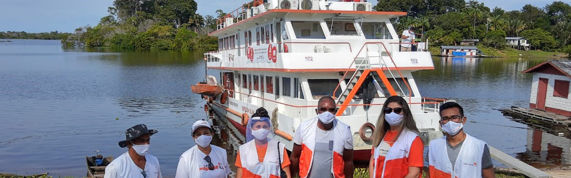 Helfer von World Vision stehen vor dem Schiff, das vom Corona-Virus betroffene Flussuferbewohner im Amazonas mit Medikamenten versorgt Helfer von World Vision stehen vor dem Schiff, das vom Corona-Virus betroffene Flussuferbewohner im Amazonas mit Medikamenten versorgt