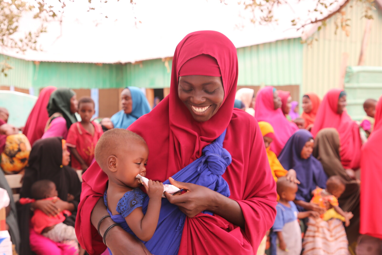 Frau mit Kind, das Notfallnahrung gegen Hunger erhalten hat, in Somalia