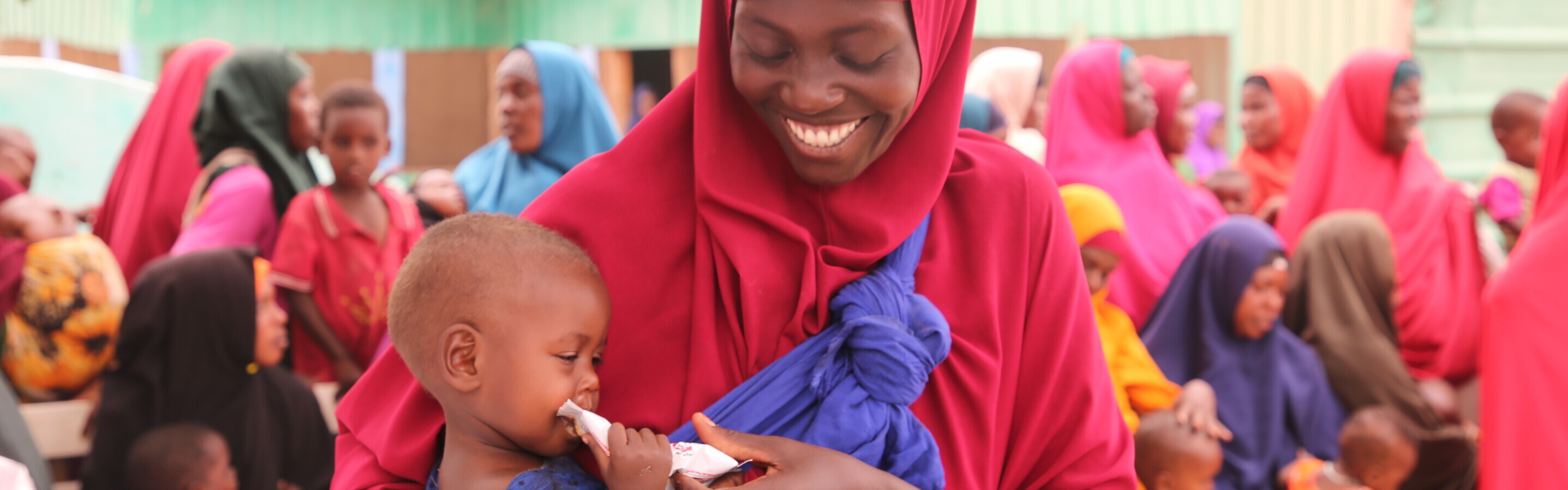 Frau mit Kind, das Notfallnahrung gegen Hunger erhalten hat, in Somalia