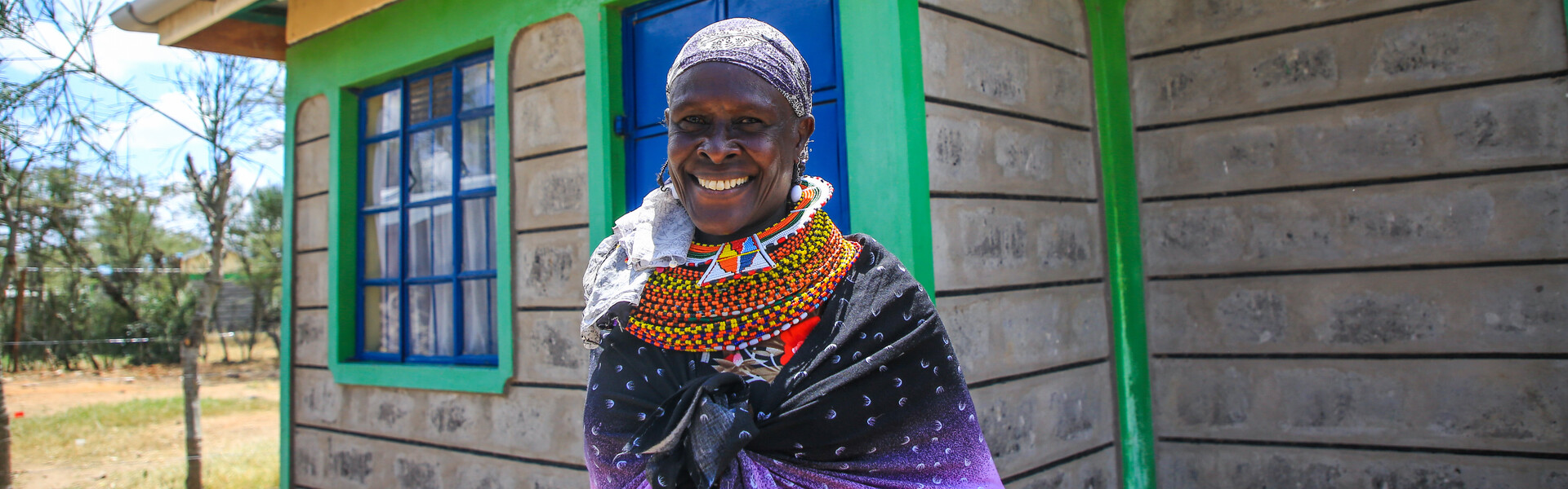 A female massai in Kenya stands in front of a house A female massai in Kenya stands in front of a house