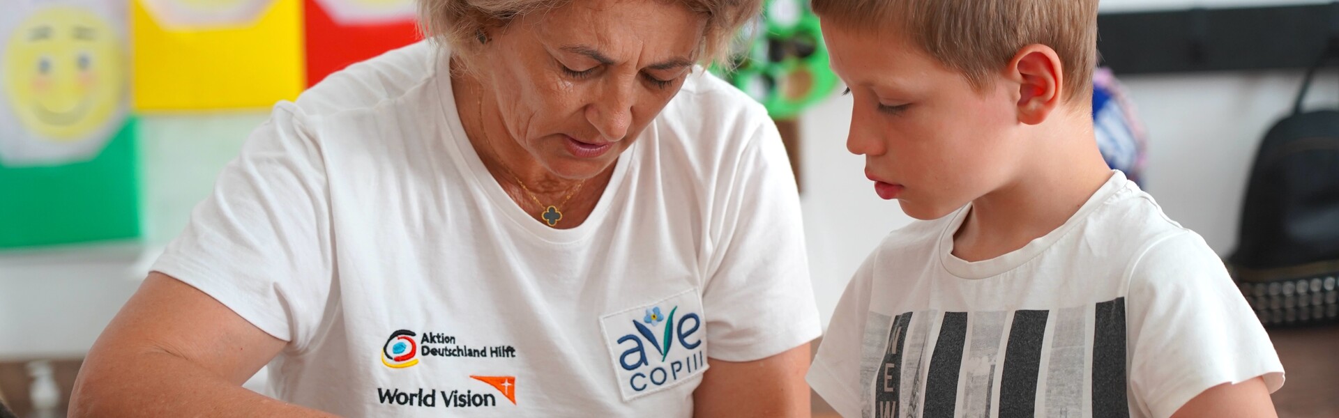 Eine Helferin der Organisation Ave Copiii arbeitet mit einem Kind gemeinsam an einem Bastelprojekt Eine Helferin der Organisation Ave Copiii arbeitet mit einem Kind gemeinsam an einem Bastelprojekt