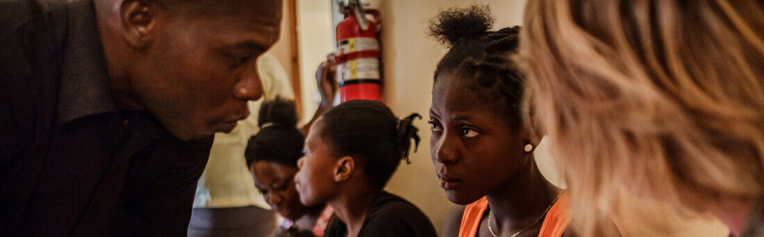 Helferin und zwei Haitianer in einer Notunterkunft Helferin und zwei Haitianer in einer Notunterkunft